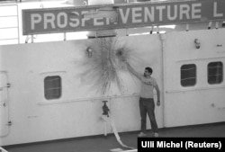 A crewman of a Panamanian-flagged tanker points out the impact site of a rocket-propelled grenade fired from an Iranian gunboat in October 1987.