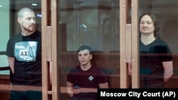 Бывшие полицейские Максим Уметбаев, Акбар Сергалиев и Игорь Ляховец слушают приговор в зале заседания Мосгорсуда в Москве, 28 мая 2021 года