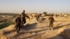 Afghan security personnel stand guard in Chardara district of Kunduz province in June.
