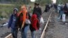 Határsértők gyalogolnak a Horgos–Szeged vasútvonalon a magyar–szerb határnál, Röszke közelében 2015. szeptember 8-án