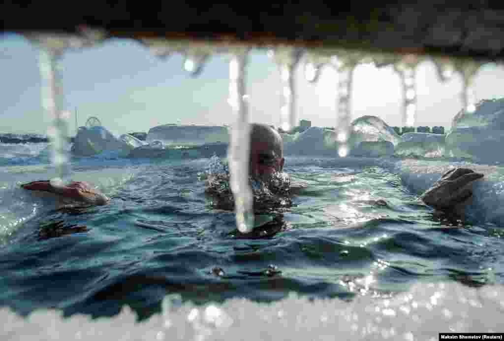 A swimmer takes a dip in the icy waters of the Amur River in Blagoveshchensk, Russia. (Reuters/Maxim Shemetov)