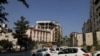 Motorists pass a damaged building after it was targeted by an Israeli strike in the Iranian capital Tehran, on June 13, 2025.
