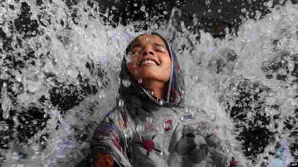 A Pakistani girl cools off in a water channel in Lahore. A heatwave saw temperatures in excess of 40 degrees Celsius in many parts of the country. (AFP/Arif Ali)