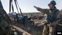 Український військовий вказує на позиції бойовиків поблизу Гнутова на Маріупольскому напрямку (архівне фото)