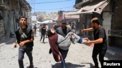 Palestinac nosi ženu, ranjenu u izraelskom napadu u gradu Gazi, 30. maja 2025.