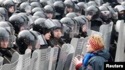 Участница протестов в Киеве стоит перед отрядом милиции. 21 января 2014 года.