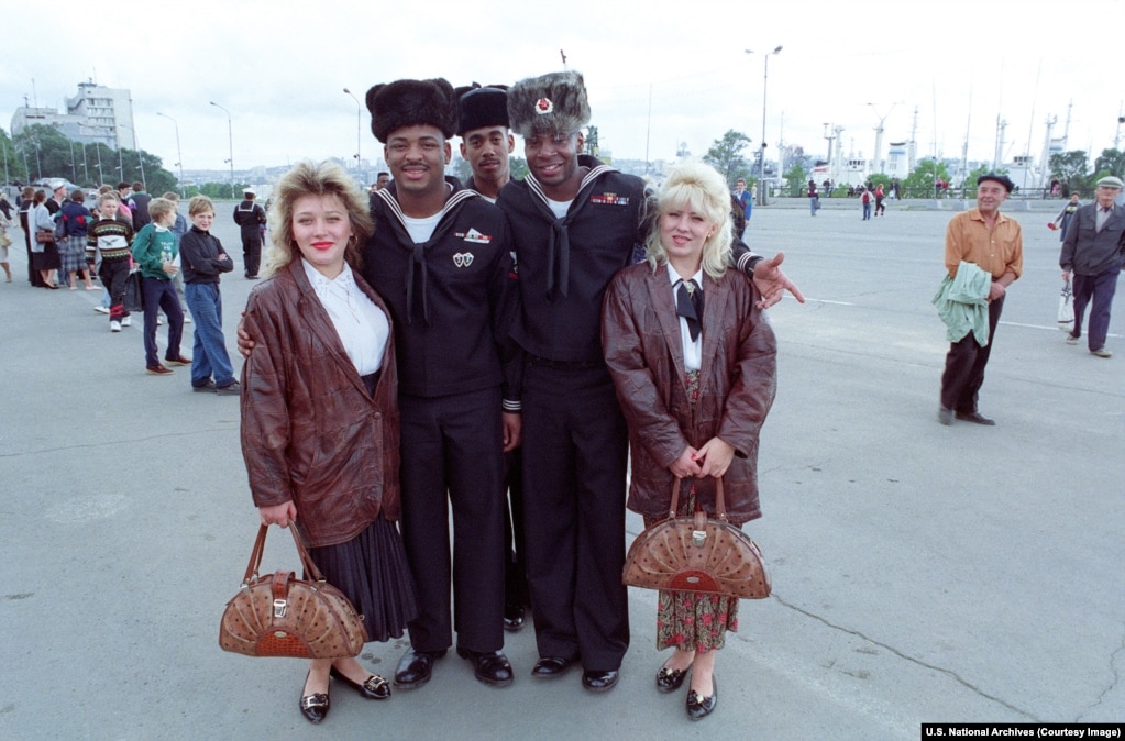 U.S. sailors wear souvenir Soviet hats as they pose with local women in Vladivostok in September 1992 during a three day “goodwill port call” by the U.S. Navy.