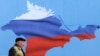 Ukraine -- A man walks past a poster depicting Crimea in the colors of the Russian flag, in Sevastopol, March 11, 2014