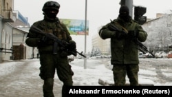 Armed, masked men block off a street in the center of the separatist-controlled city of Luhansk on November 22.