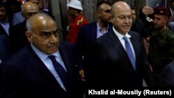 Barham Salih (right), Iraq's newly elected president, walks with new Prime Minister Adel Abdul-Mahdi at the parliament in Baghdad on October 2.