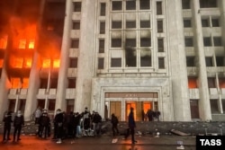 Protesters are seen outside the burning office of the Almaty mayor on January 5, 2022.