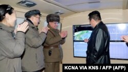 An official North Korean photo shows the country's leader Kim Jong Un (right) speaking with military officials during what state media said was a hypersonic missile test on January 11. 