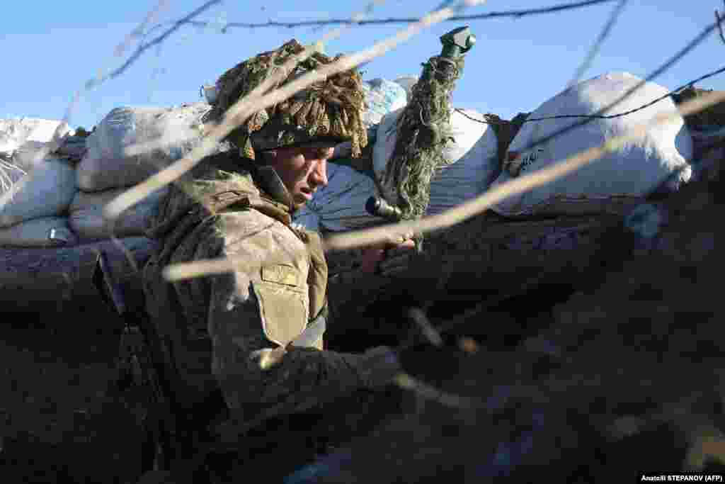 A Ukrainian soldier stands in a trench on the front line with Kremlin-backed separatists near Avdiyivka in southeastern Ukraine.