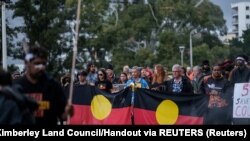 Demonstranti nose zastave australijskih Aboridžina dok učestvuju u maršu protiv, kako kažu, nedostatka detalja i konsultacija o novim zakonima o zaštiti naslijeđa, 19. augusta 2021.