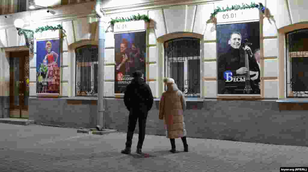 Парень с девушкой изучают афиши январских спектаклей театра имени Луначарского