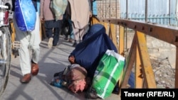 A woman begs on the street in Ghazni city. Many women have lost all income, despite being the sole wage earners for their families.