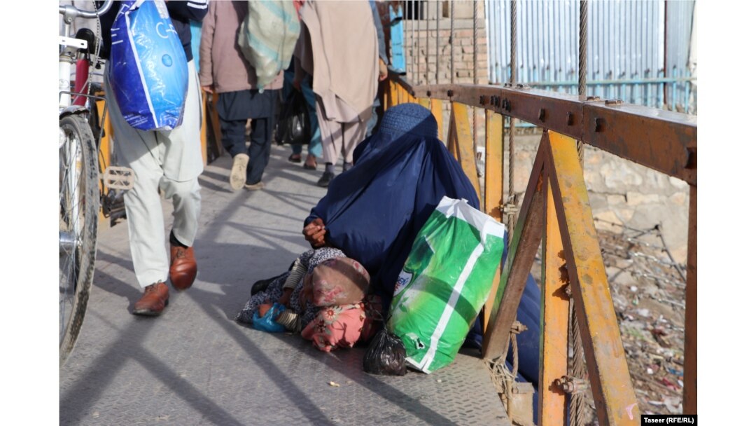 A woman and child beg on the street in Ghazni city.