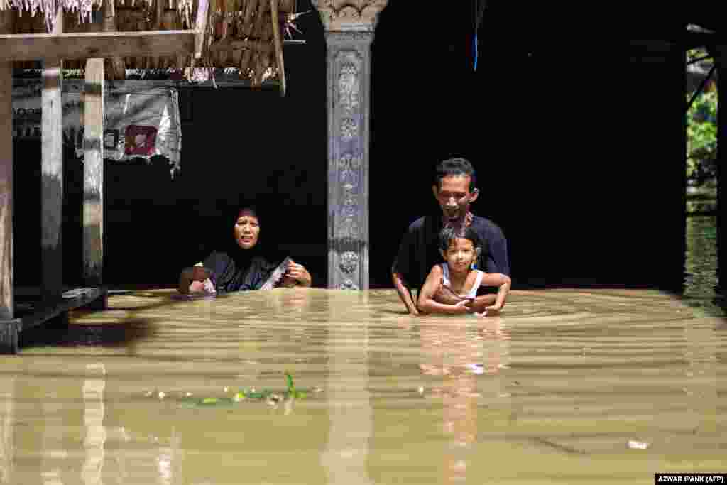 Aceh tartomány északi részén még most is sok helyen mellmagasságig ér a víz. Egy férfi próbál családjával átgázolni az áron január 4-én&nbsp;