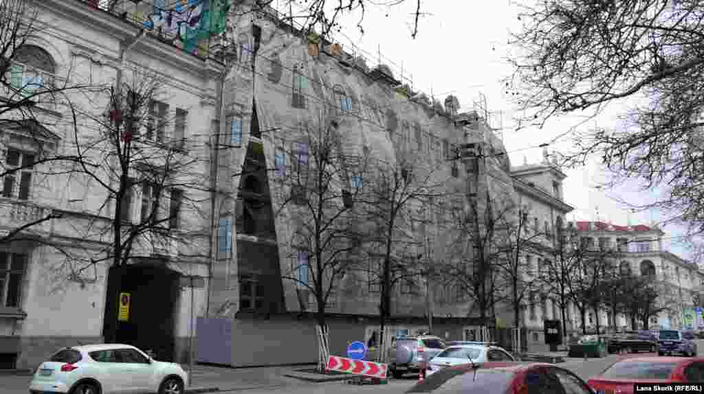 Вітер відірвав і надуває, ніби вітрило, декоративний банер, що закриває будівельні риштування біля фасаду Художнього музею імені М.П. Крошицького