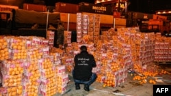 A customs agent checks boxes of oranges, which incuded fake fruit filled with captagon, after the shipment was intercepted at the Beirut port in December 2021.