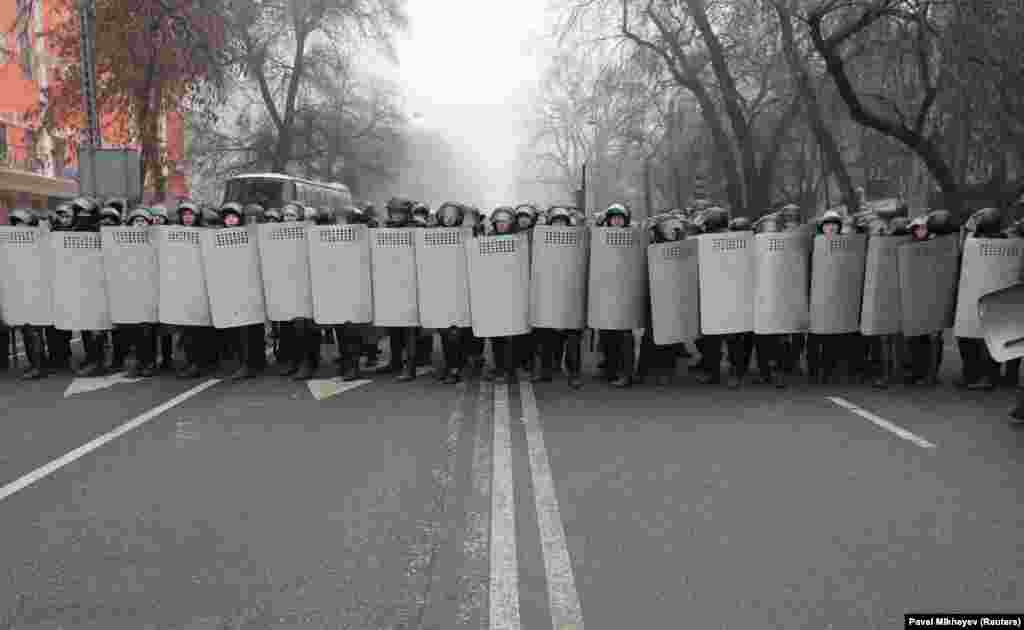 Police form a wall of shields in Almaty on January 5.&nbsp;