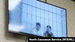 Salekh Magamadov and Ismail Isayev are seen on a video monitor in a courtroom in Achkhoi-Martan.