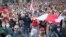 People with old Belarusian national flags march during an opposition rally to protest the official presidential election results in Minsk on October 4.