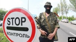 A pro-Russian militant stands guard at a checkpoint on the road from Donetsk to Mariupol.