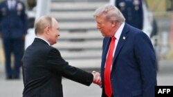 აშშ-ის პრეზიდენტი დონალდ ტრამპი (მარჯვნივ) მიესალმება რუსეთის პრეზიდენტს, ვლადიმირ პუტინს. ალასკა. 2025 წლის 15 აგვისტო 