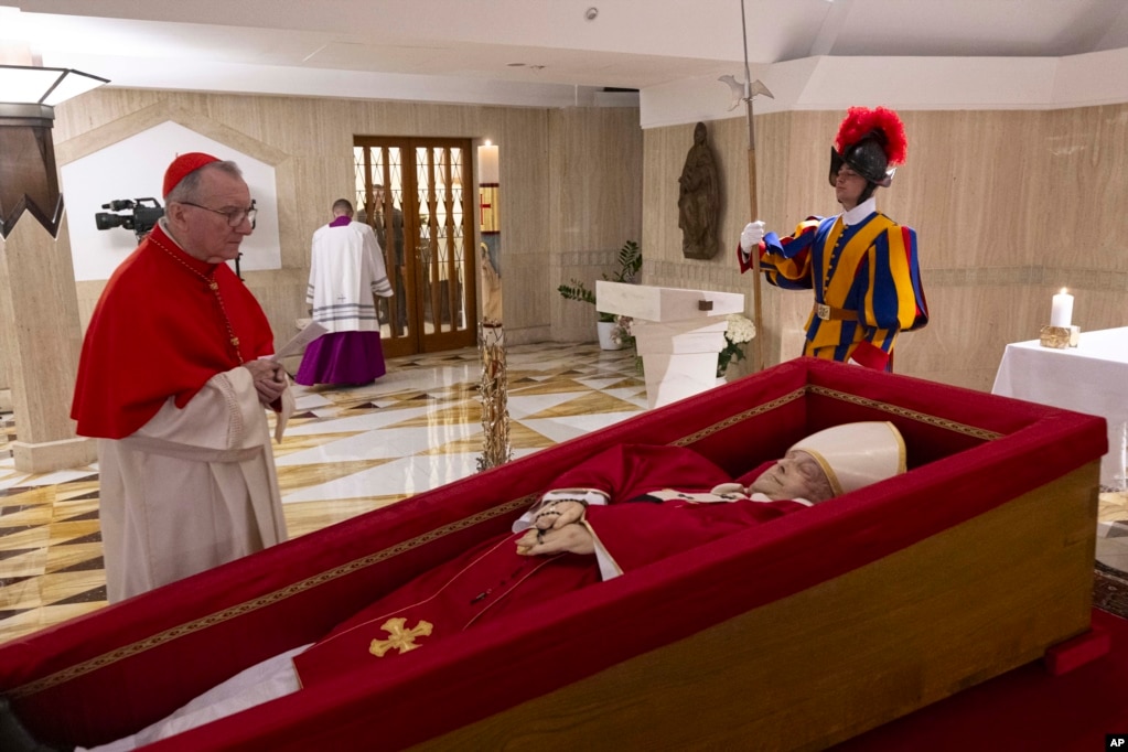 Sekretari i Shtetit të Vatikanit, kardinali Pietro Parolin, majtas, lutet para trupit të Papa Françeskut, i vendosur në arkivol, në Vatikan.