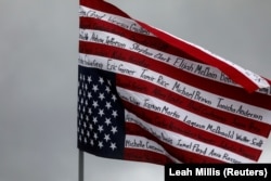 Američka zastava okrenuta naopako sa ispisanim imenima Afroamerikanaca ubijenih u policijskom pritvoru i u drugim incidentima na protestnom maršu u Minnesoti, 13. april 2021.