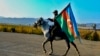 AZERBAIJAN -- An Azerbaijani soldier with a national flag rides a horse in Ganca, Azerbaijan's second largest city, near the border with Armenia, November 10, 2020