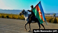 Азербайджанский военный едет верхом на лошади и держит флаг своей страны. Город Гянджа, недалеко от границы с Арменией. 10 ноября 2020 года
