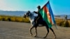 An Azerbaijani soldier with a national flag rides a horse in Ganca, Azerbaijan's second-largest city, near the border with Armenia, on November 10.