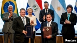 Еврокомисарят по търговията Марош Шефчович и външният министър на Парагвай Рубен Рамирес Лескано на преден план. Зад тях: председателите на Европейския съвет и ЕК Антонио Коща и Урсула фон дер Лайен и президентите на Парагвай и Аржентина Сантяго Пеня и Хавиер Милей