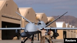 U.S. airmen prepare a US Air Force MQ-9 Reaper drone as it leaves on a mission at Kandahar Air Field in March.