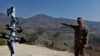 A Pakistan army officer points to the site where an Indian fighter jet was shot down and its pilot, Wing Commander Abhinandan Varthaman, was captured in Horran village, near the Line of Control, in February.