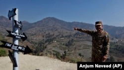 A Pakistani Army officer points out the site where an Indian fighter jet was shot down and its pilot, Wing Commander Abhinandan Varthaman, was captured, during an event in Horran village, near the Line of Control.