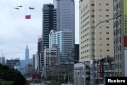 Elicoptere ale forțelor armate din Taiwan au survolat în formație centrul capitalei Taipei cu ocazia depunerii jurământului de către noul președinte Lai Ching-te. În plan îndepărtat: Taipei 101, clădirea care a fost o vreme cea mai înaltă din lume.