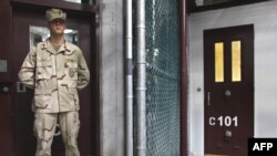 A guard stands inside a doorway at Camp 6 detention facility at Guantanamo Bay.