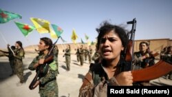 Syrian Democratic Forces (SDF) female fighters hold their weapons during a graduation ceremony in the city of Hasaka, northeastern Syria, August 9, 2017