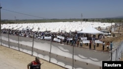 A Turkish soldier stands guard outside of a refugee camp in the Turkish border town of Boynuegin on June 17.