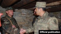 Zakir Həsənov (sağda) əsgərlə görüşür. 