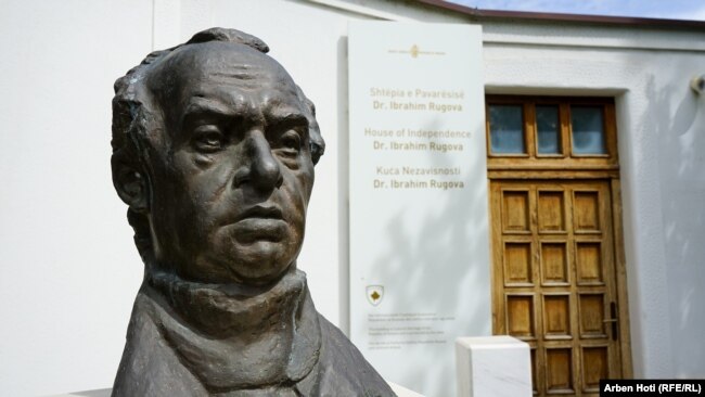 Busti i Ibrahim Rugovës qëndron pranë muzeut "Shtëpia e Pavarësisë Dr.Ibrahim Rugova".