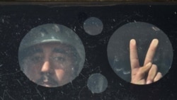 An Afghan Army soldier flashes the victory sign from an armored vehicle during a training session in Herat on September 24.