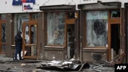 Un polițist ucrainean inspectează locul unei explozii care a distrus un magazin din Liov, pe 22 februarie 2026