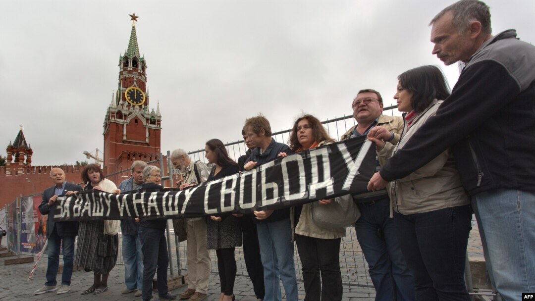 Human rights activist Natalya Gorbanevskaya (4th from left) attends a memorial protest action on Red Square in Moscow on August 25, 2013, with the banner "For your freedom and ours."