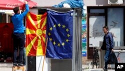 Zemlja je pokazala posvećenost postizanju rezultata u ključnim oblastima, navodi se u Izveštaju o Severnoj Makedoniji (na fotografije zastave Severne Makedonije i EU na ulicama Skoplja 2019. godine)