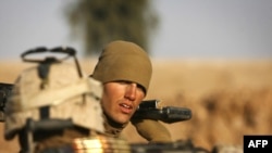 A U.S. Marine gears up for a mission northeast of Marjah in Helmand Province.