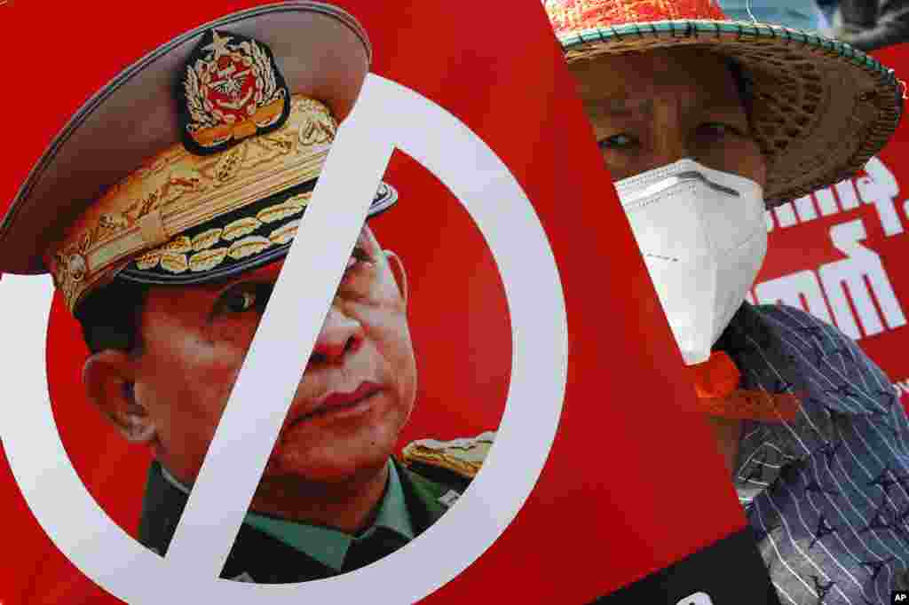 Протестувальник тримає плакат із перекресленим зображенням головнокомандувача, старшого генерала Мін Аун Хлаін, він є також головою Державної адміністративної ради, під час мітингу проти перевороту перед будівлею Економічного банку М&#39;янми в Мандалаї, 15 лютого 2021 року